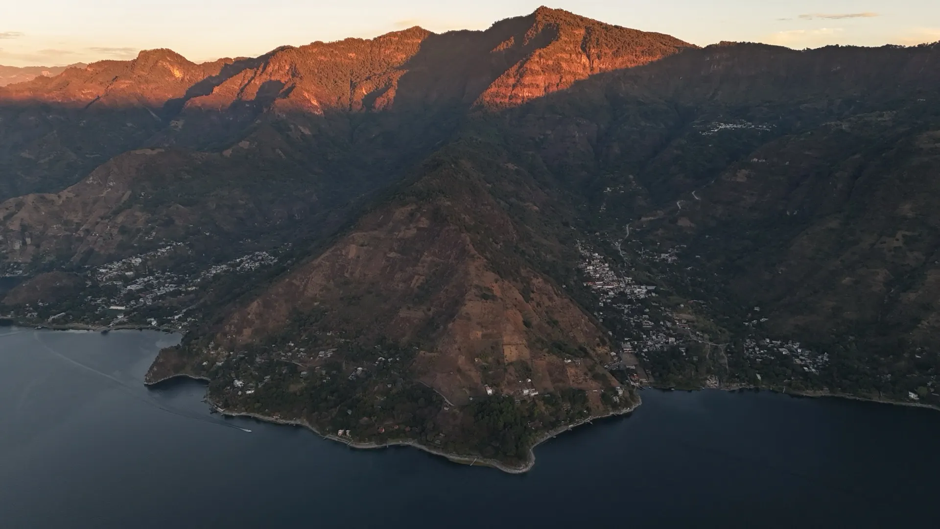 Pasajcap ridge at sunrise over Lake Atitlán — three volcanoes catching first light