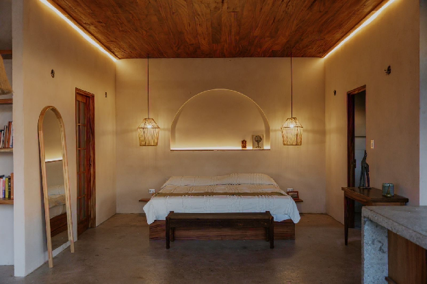 Studio bedroom with wood ceilings, polished concrete floors, and well-appointed interior lighting