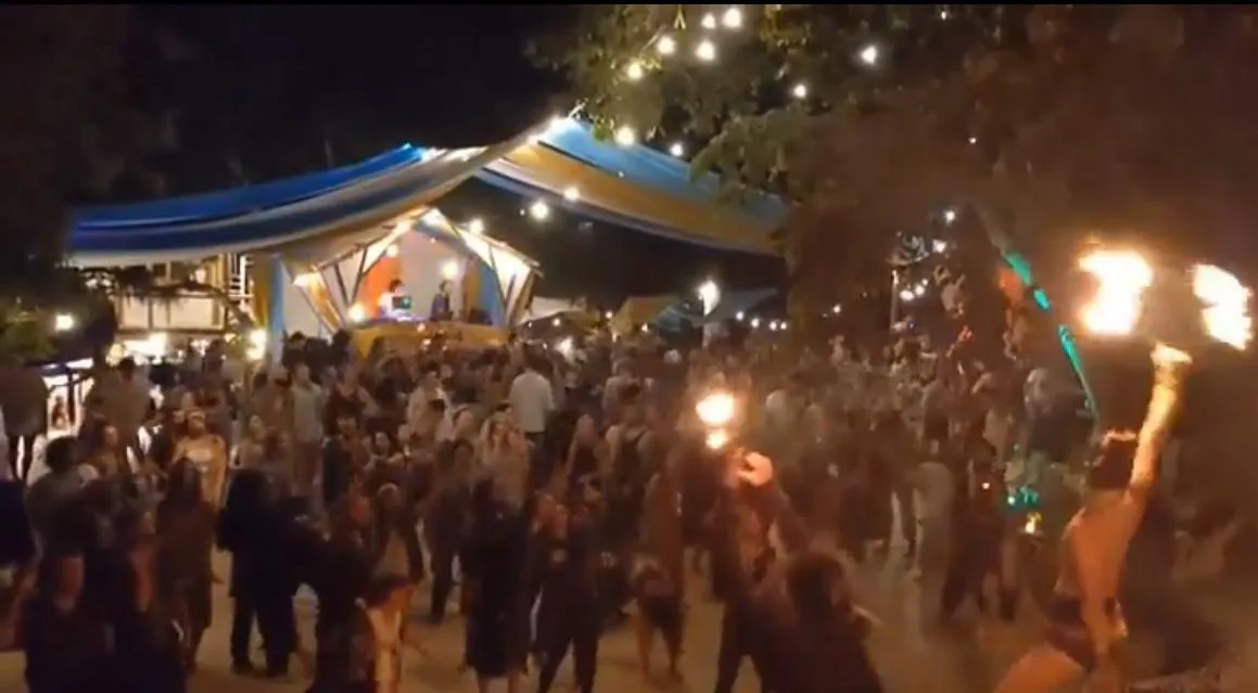 An evening ecstatic dance at the Gaia Dance Temple in Tzununá, a crowd gathered under string lights with fire performers