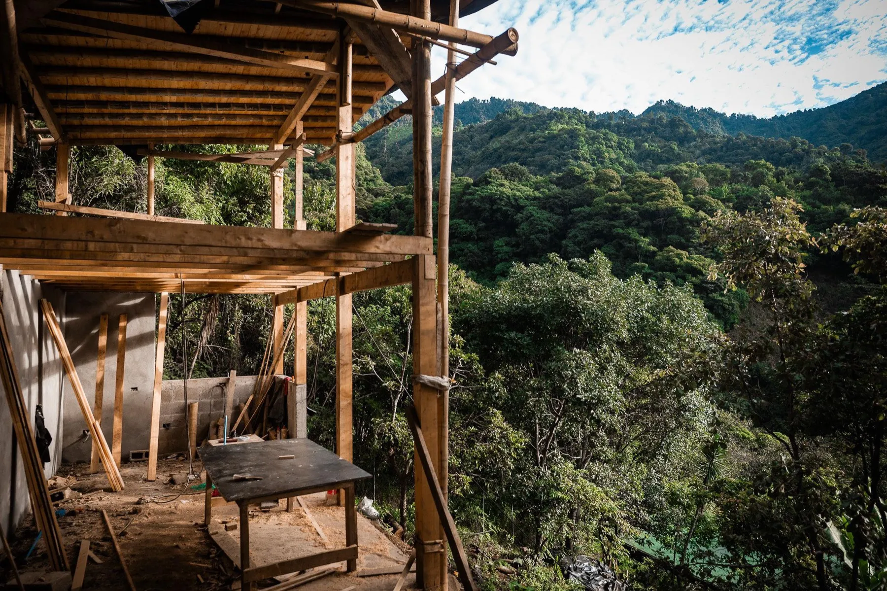 WuWei Village's Casa Orchidea under construction — a timber and bamboo home framed against the forested Tzununá hillside